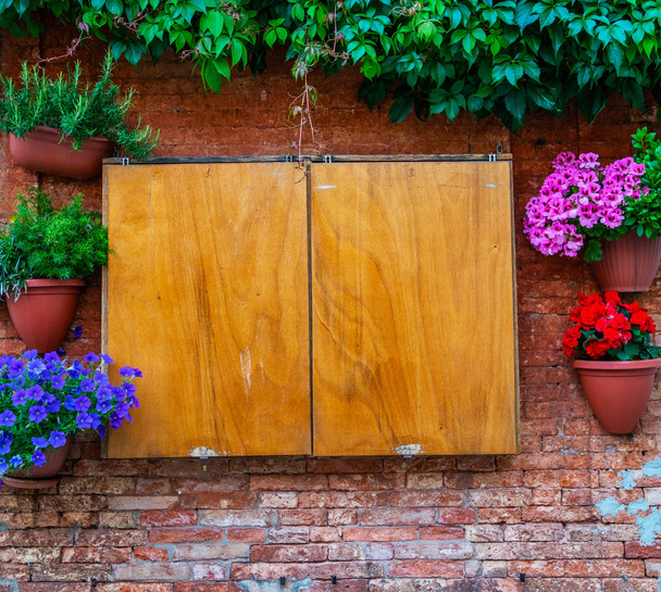 Vecchia scatola di legno su un muro di mattoni vintage con fiori a Venezia
 - Foto, immagini