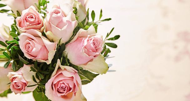Bunch of beautiful fresh pink roses with greenery over a textured neutral background with copy space - Foto, Imagen