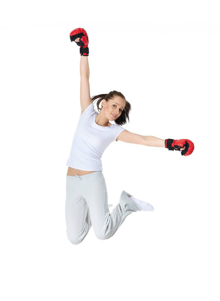 Sporty young woman in red fighting gloves on a white background. - Foto, Imagen