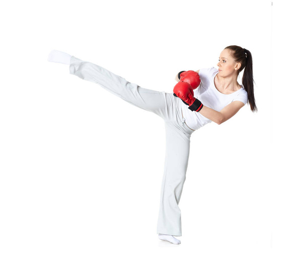 Urheilullinen nuori nainen punaisissa taistelukäsineissä valkoisella taustalla
. - Valokuva, kuva