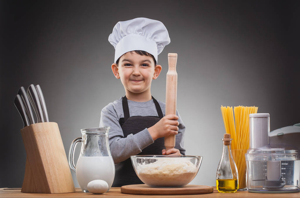 Boy Chef Cooking on a gray background. - Φωτογραφία, εικόνα