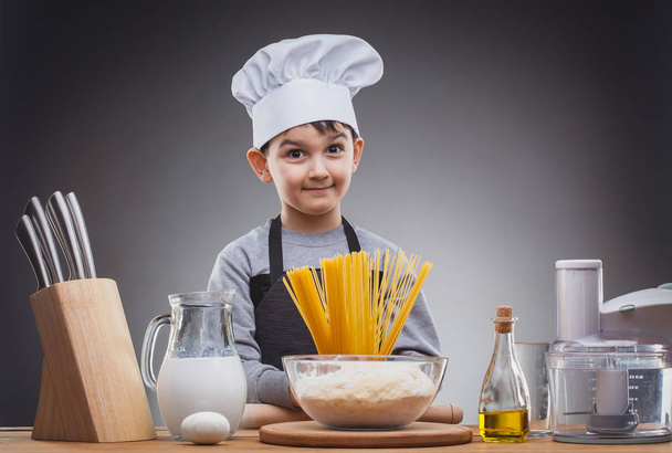 Boy Chef Cooking on a gray background. - Zdjęcie, obraz