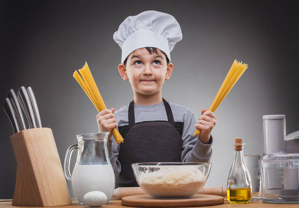 Boy Chef Cooking on a gray background. - Foto, afbeelding
