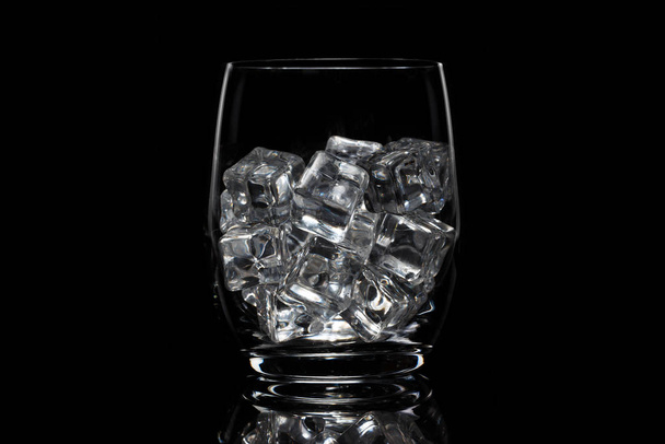 Glass cup with ice on a black background - Foto, Bild