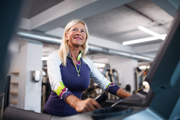 A senior woman in gym doing cardio work out exercise. - Valokuva, kuva