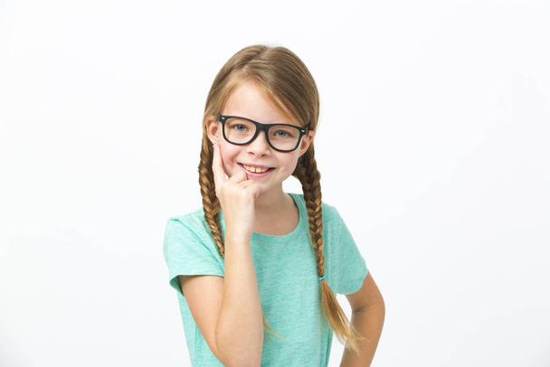 pretty girl with black glasses and plaits in front of white background in the studio - Фото, изображение