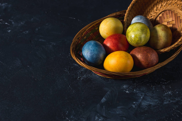 Huevos de Pascua brillantes multicolores. Huevos de Pascua sobre un símbolo de fondo oscuro. Cristo ha resucitado Copyspace primer plano
 - Foto, imagen