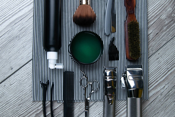Flat lay from hairdressing accessories including: haircuts, scissors, combs, gels for styling and shaving laid - Photo, Image