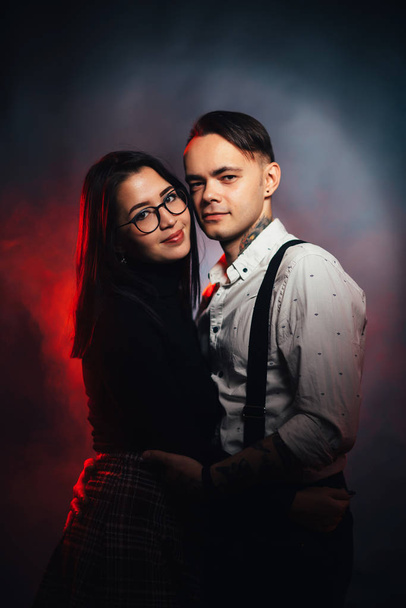 Couple in fashionable clothes on a dark smoky background. - Foto, immagini