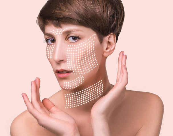 The lifting, skin, plastic surgery concept. Woman face with marks and arrows. Portrait of young caucasian woman at studio isolated on pastel. Short haircut, long neck, perfect skin. Lifting by gold thread concept - Фото, изображение