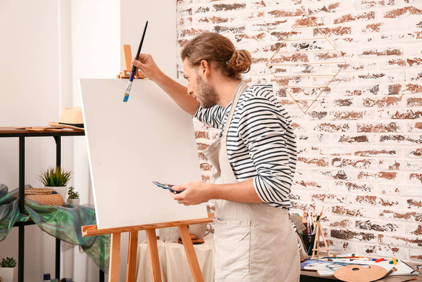 Joven artista masculino pintando en casa
 - Foto, Imagen