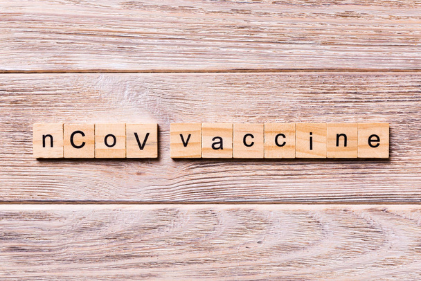 ncov λέξη εμβόλιο γραμμένο σε ξύλο μπλοκ. ncov κείμενο εμβόλιο στο ξύλινο τραπέζι για desing σας, coronavirus έννοια κορυφή άποψη - Φωτογραφία, εικόνα