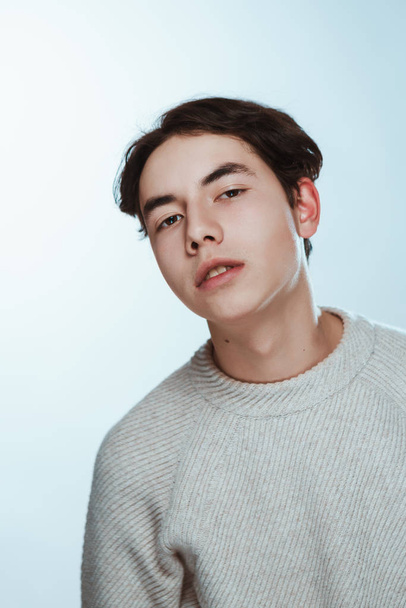 Studio portrait young man in grey sweater on white background. - Photo, image