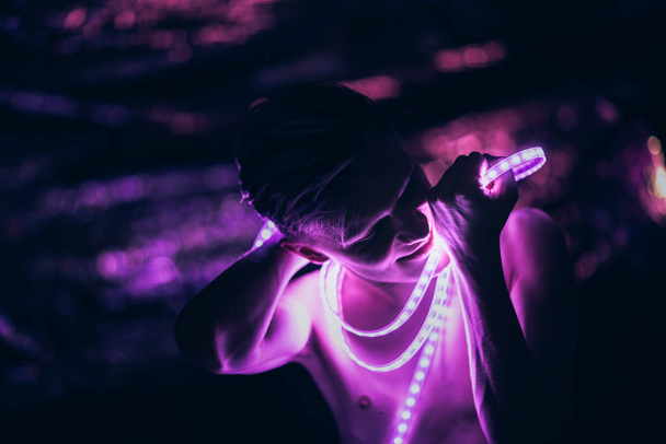 Portret man Strip Licht LED tape op donkere achtergrond. - Foto, afbeelding
