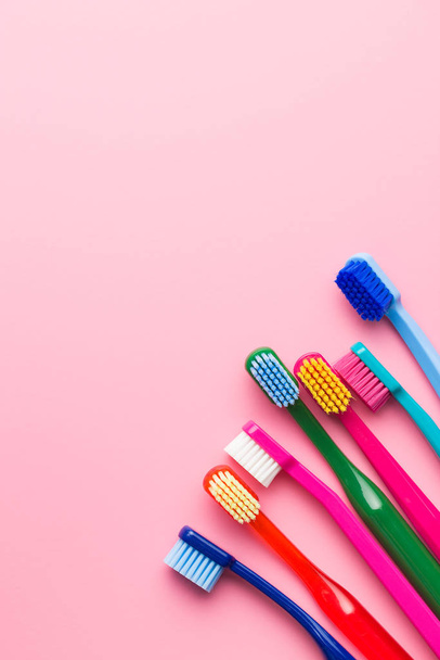 Colorful toothbrushes on pink background. Top view. - Photo, image