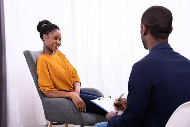 Young African Woman Sitting Near Psychologist With Clipboard To Treat Depression - Фото, зображення