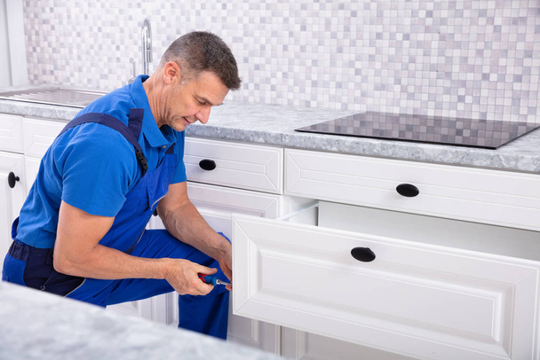 Close-up Of A Male Handyman Installing Door Of Drawer In The Kitchen - Foto, Bild