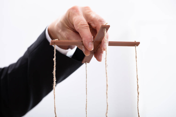 Close-up Of A Businessperson's Hand Manipulating Marionette With A String  - Fotó, kép