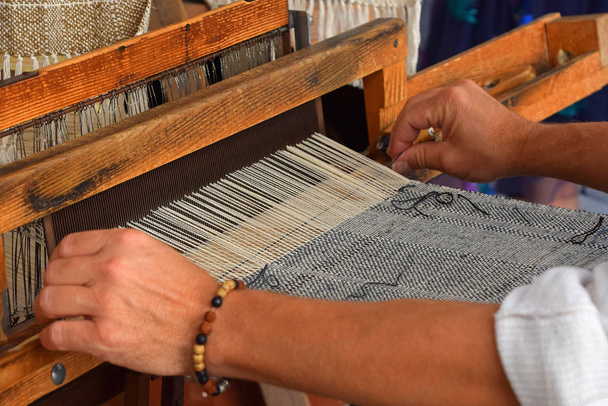 Close up man hands weave canvas with antique loom handweave machine, side view - Photo, image