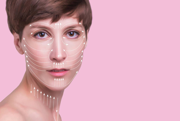 Beautiful woman's face with massage lines isolated on pink. - Фото, изображение