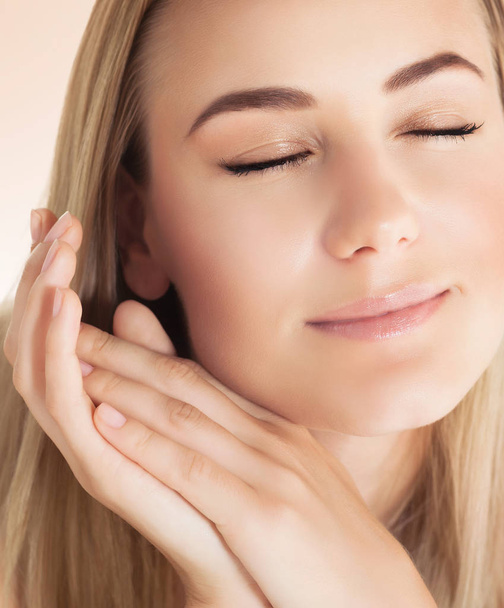 Closeup portrait of a nice blond girl with closed eyes with pleasure applying facial cream, using natural beauty treatment, health and beauty care concept. - Foto, Imagen