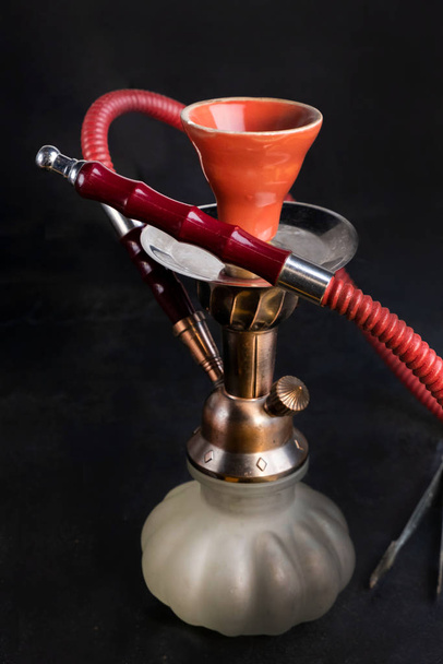 Красный классический турецкий арабский курильщик восточный кальян шиша калиан с яблочным вкусом на черном фоне
  - Фото, изображение