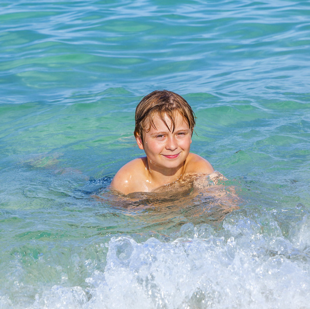 jongen geniet van het heldere water in de Oceaan - Foto, afbeelding