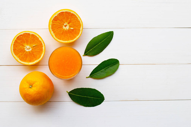 Fresh orange citrus fruit with leaves and Orange juice  on white wooden background - Photo, image