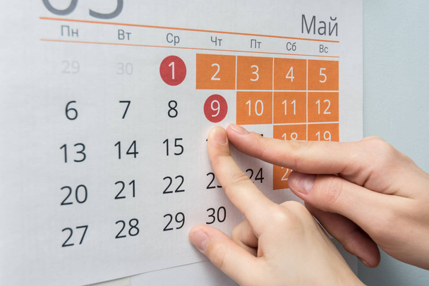 Child and adult hands indicate the date of May 9 wall calendar - 写真・画像
