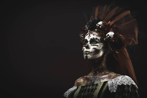 Santa Muerte Young Girl with Artistic Halloween Makeup and with Sculls in her Hair - Fotografie, Obrázek