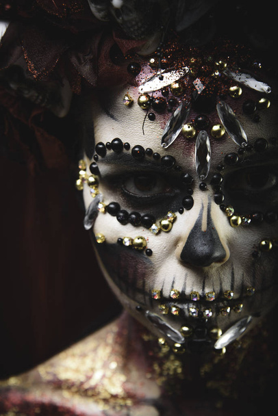 Santa Muerte Young Girl with Artistic Halloween Makeup and with Sculls in her Hair - Foto, imagen
