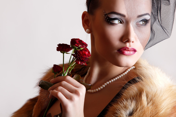 Beautiful woman with dark red roses - 写真・画像