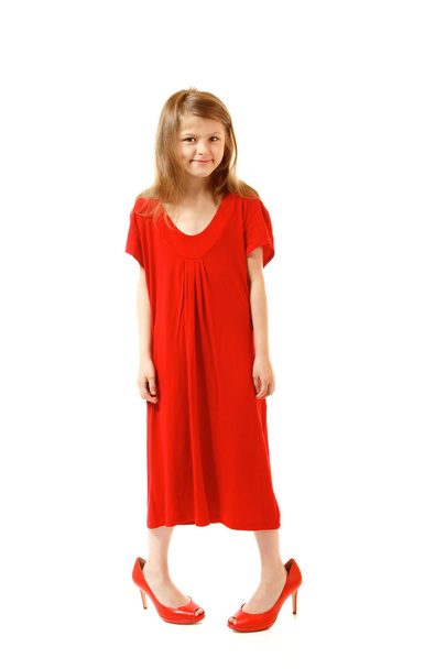 Little fashion girl in mother's red dress and shoe's on high heels - Foto, afbeelding