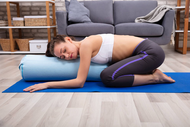 Young Woman Practicing Yoga On Bolster At Home - Foto, Bild