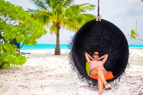 Beautiful woman relaxes on a swing on the dream beach - Foto, Imagem