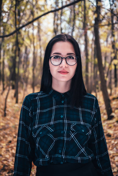 portrait of a young woman in the autumn forest. - 写真・画像