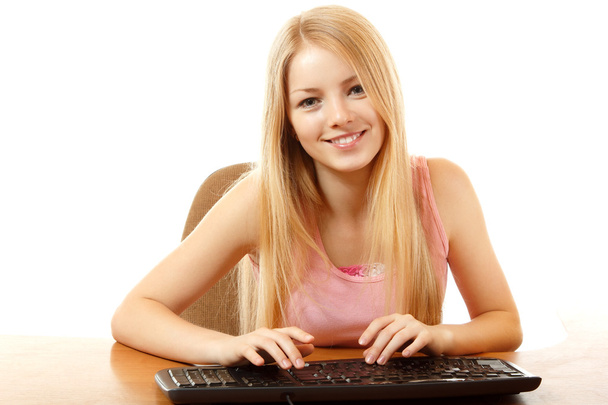 Teen girl with keyboard looking at camera with interest like in monitor - Photo, image