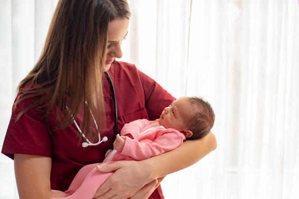 Pediatra sosteniendo una hermosa niña recién nacida
 - Foto, imagen