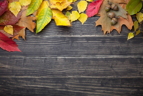 Autumn leaves and acorns on wooden table. Copy space. Top view - Foto, afbeelding