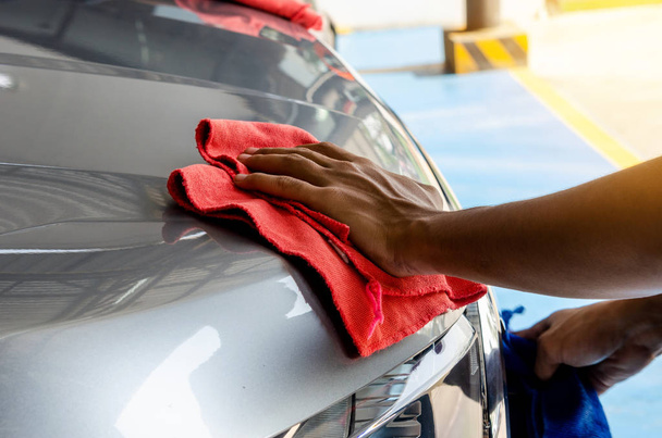 Hand with microfiber cloth, wipe the car clean - Foto, Bild