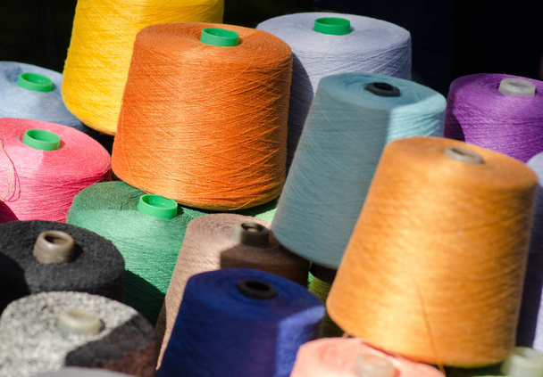 Colorful thread spools, one above the other. Coils with colurful threads. - Photo, image