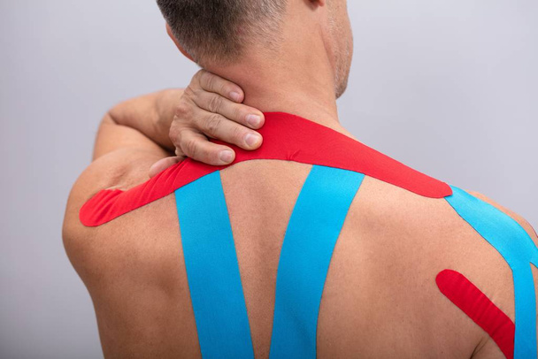 Shirtless Man With Physio Tape Applied On His Body. Body shape was altered during retouching - 写真・画像