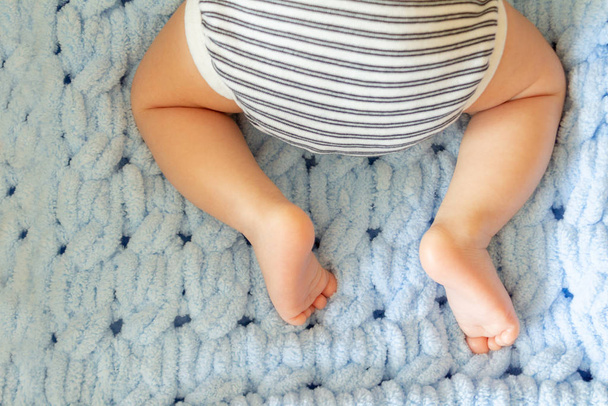  newborn baby legs in baby cot, the concept of motherhood, child care, top view - Valokuva, kuva