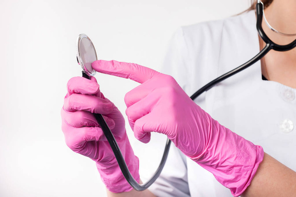doctor checks the phonendoscope while holding rubber gloves - Foto, Bild