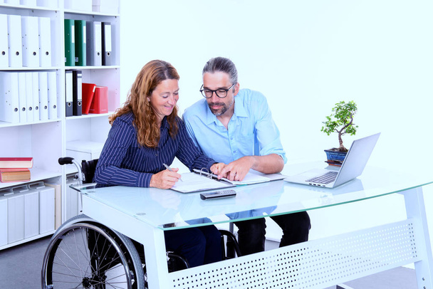 disabled businesswoman in wheelchair and her colleague in the office - Photo, image