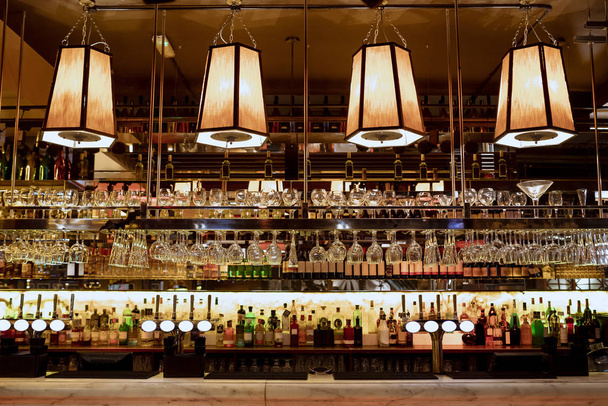 Wide angle shot of a restaurant interior of the bar counter and shelves of alcohol behind the bar. - Foto, Imagem