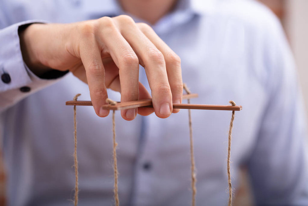 Close-up Of A Businessperson's Hand Manipulating Marionette With A String - Foto, Imagem