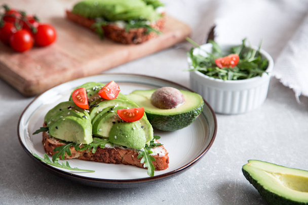 healthy breakfast with avocado and Delicious wholewheat toast. sliced avocado on toast bread with spices. Mexican cuisine/ - Фото, изображение