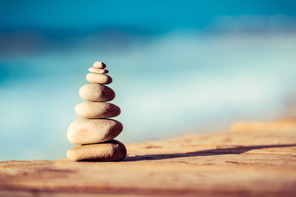 Closeup photo of a pebbles stack on the bridge over sea, spa stones, inner peace and life in balance concept. - Foto, Imagem