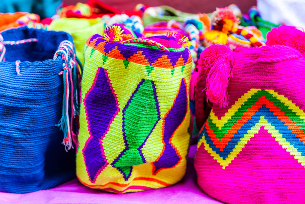 Cartagena de Indias 'ta Kolombiya' daki Wayuu topluluğunun kadınları tarafından örülmüş geleneksel el çantalarının satışı. - Fotoğraf, Görsel